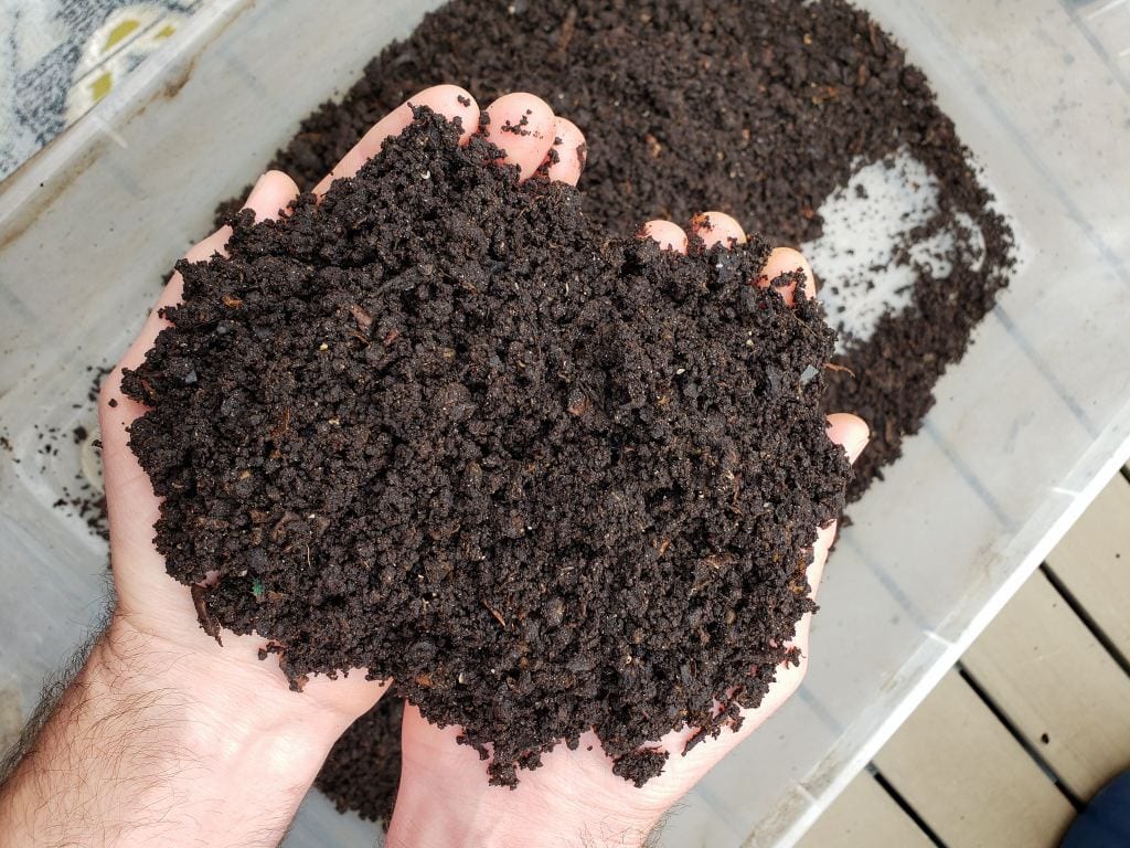 Two hands are holding some finished worm compost or vermicompost. It is rich and dark in color and has the moisture of a wrung out sponge. The castings are light and airy as well. 